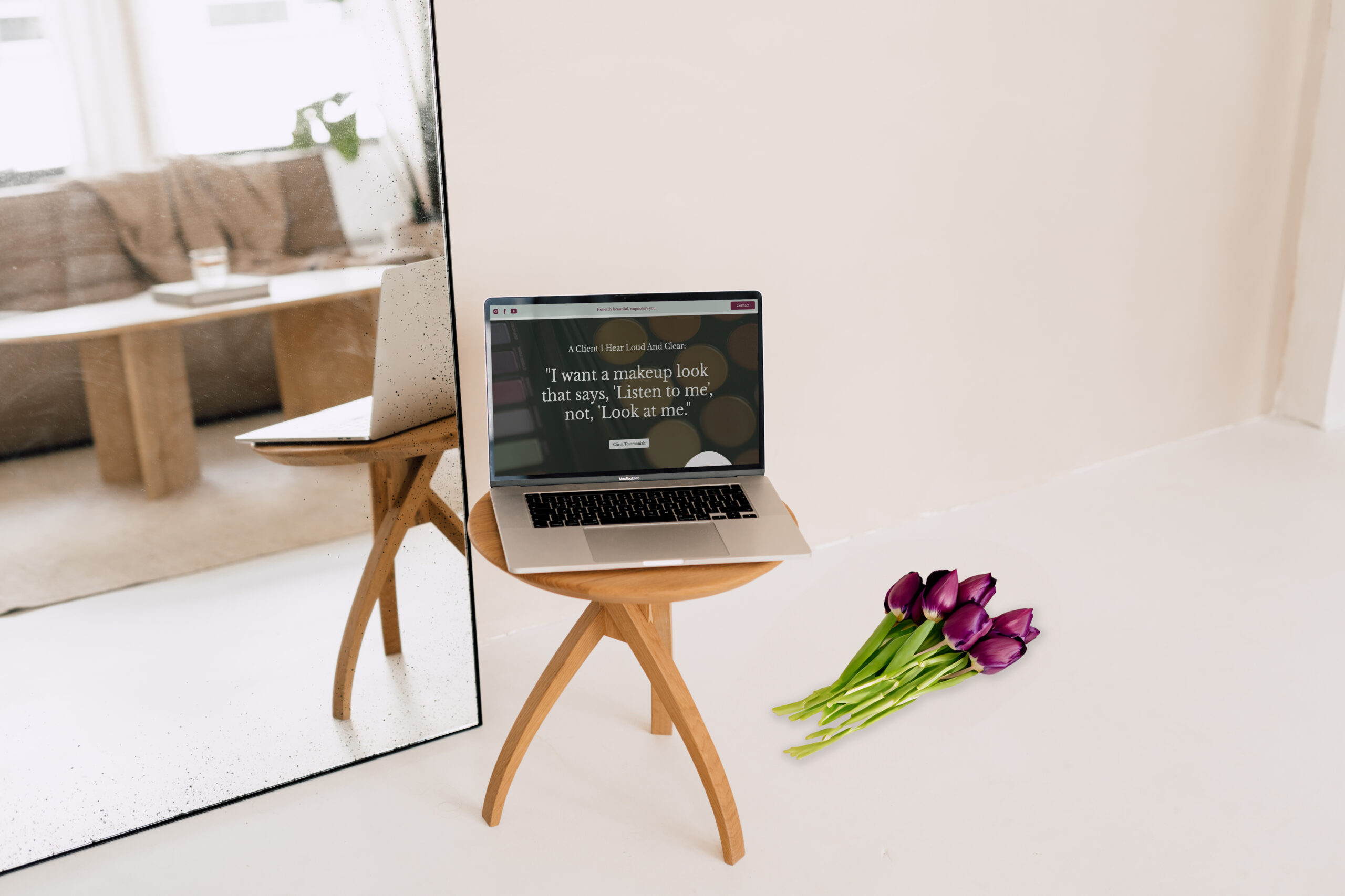 Laptop on table with tulips THI makeup artist website