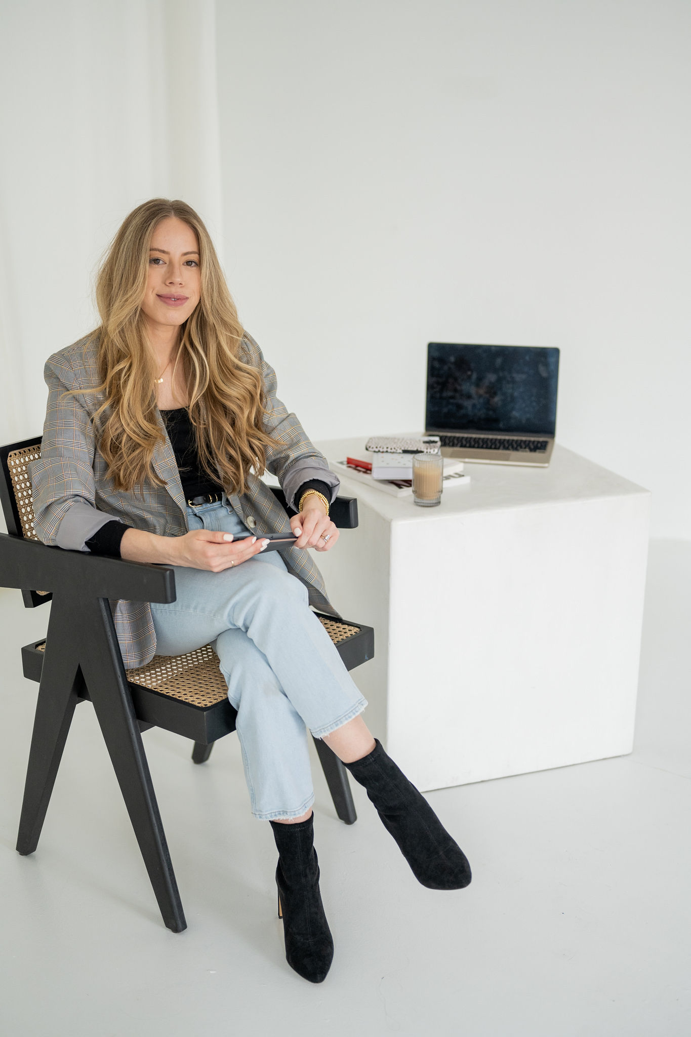 Saltd Studio's owner, Emma Rodger, sitting on a chair with her laptop on table