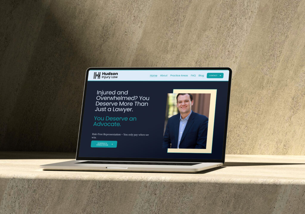 Open laptop showing the landing page for Hudson Injury Law