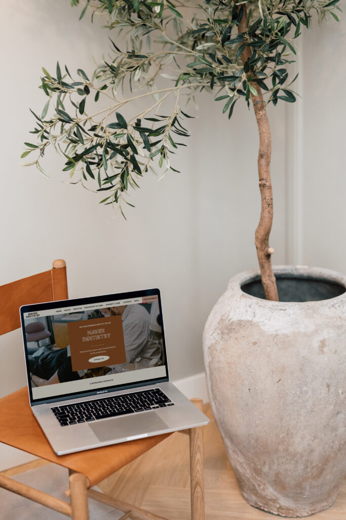 A laptop placed on a chair displaying a website landing page on the screen.