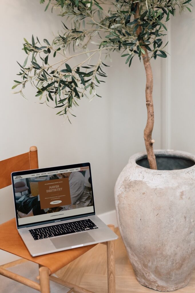 A laptop resting on a chair, showing the homepage of a dentist’s website.