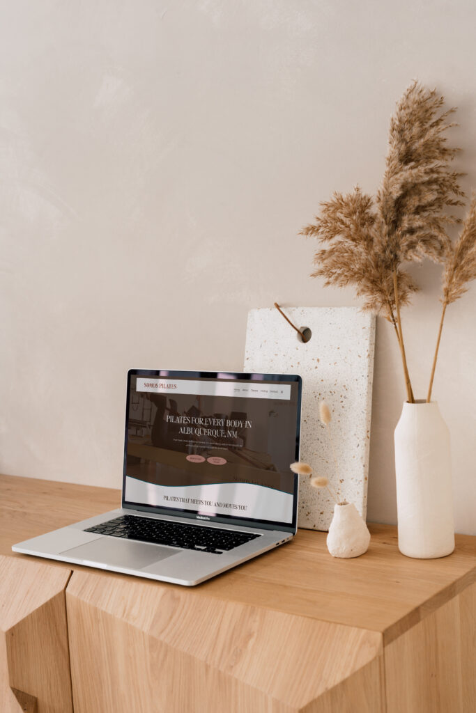Aesthetic desk with laptop showing Pilates Studio website design