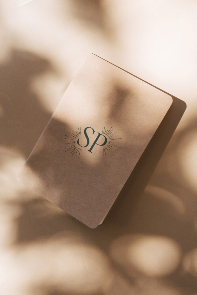 Minimal Pilates Studio logo design printed on a notebook.