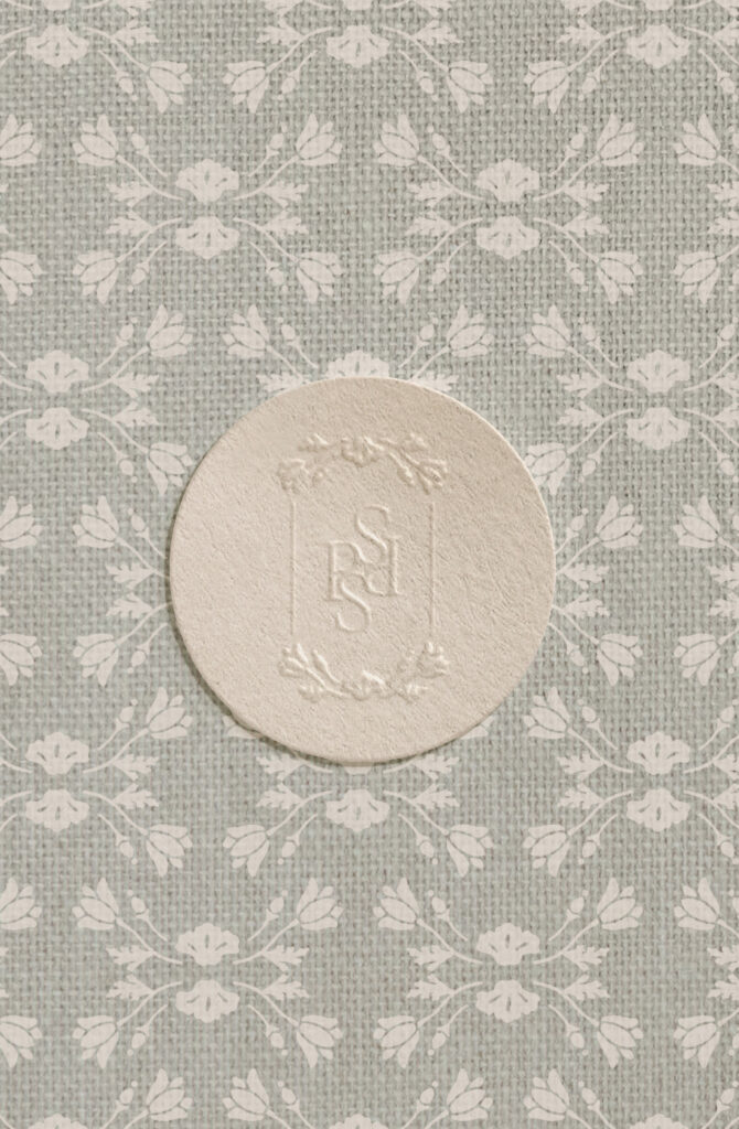 Embossed premade kit logo design with a floral background.