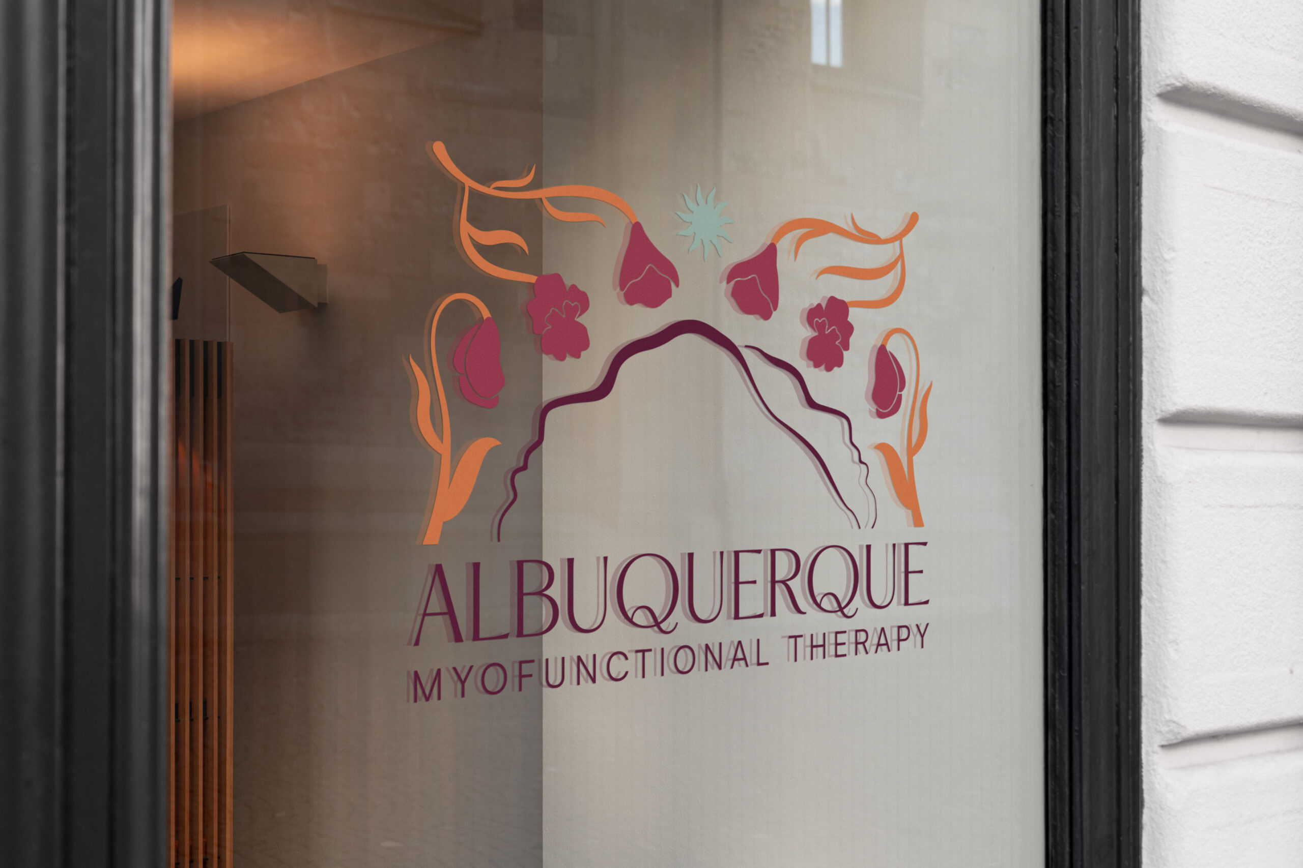 A glass door with a logo design for a myofunctional therapy office.