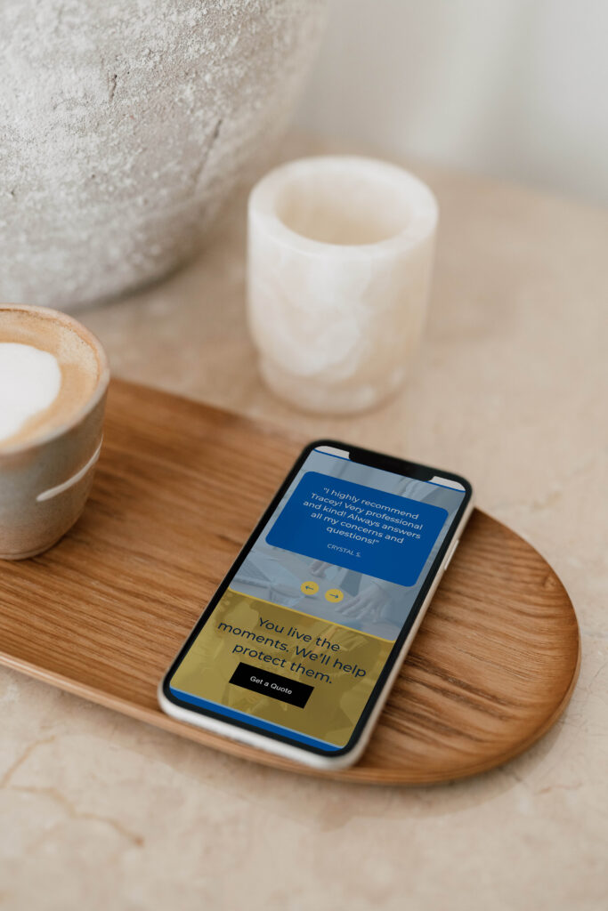 Phone resting on a wooden plate with the website’s review section on screen