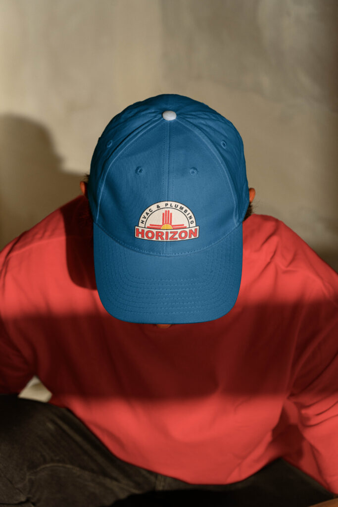 Man wearing a blue hat with a HVAC logo design by Saltd Studio