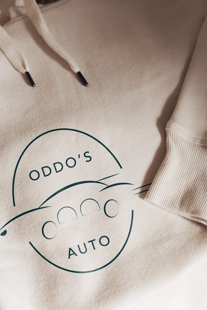Oddo’s Auto submark logo printed on a sweater.