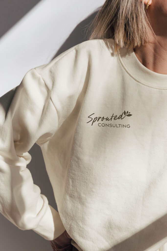 Sprouted Consulting logo displayed on a branded sweater.