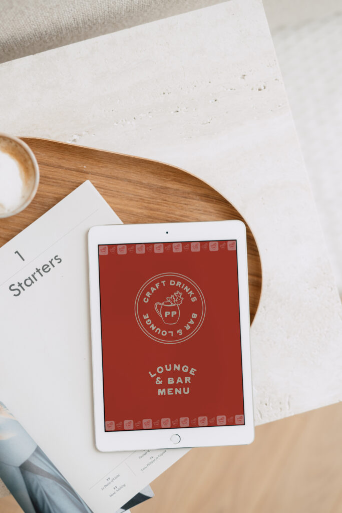 A vintage-inspired logo design for a food and beverage business displayed on a tablet screen.