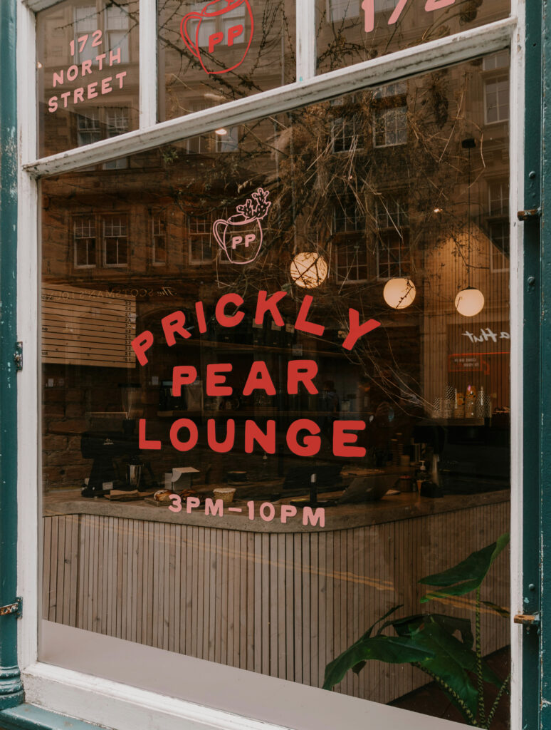 The Prickly Pear pre-made brand kit logo displayed on a glass window.