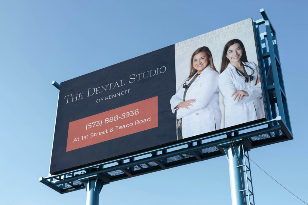 Branded billboard featuring The Dental Studio's colors and owner portraits.