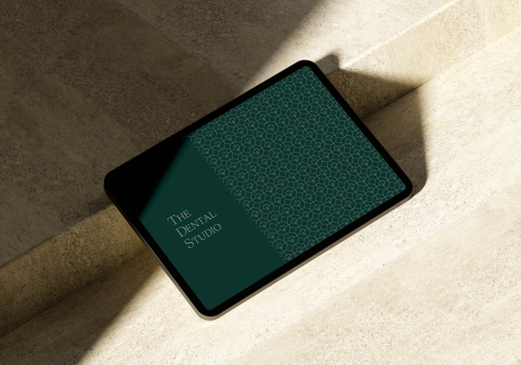 The Dental Studio logo and brand pattern are displayed on a tablet screen.